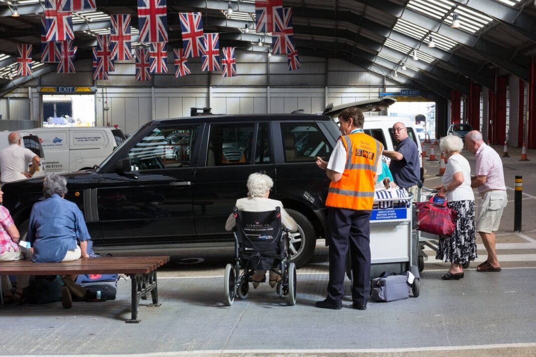 Wheelchair passengers departing cruise receiving support from Cruise line personnel. Southampton UK